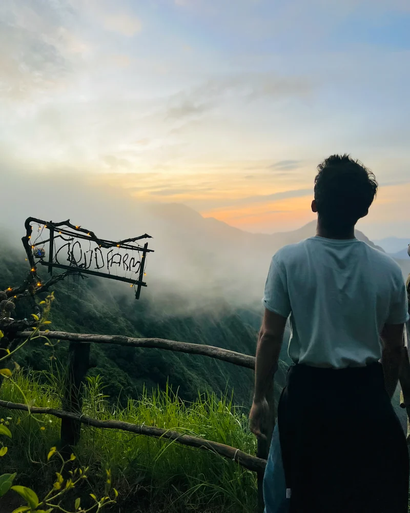 Ansith looking out over misty mountains at sunset